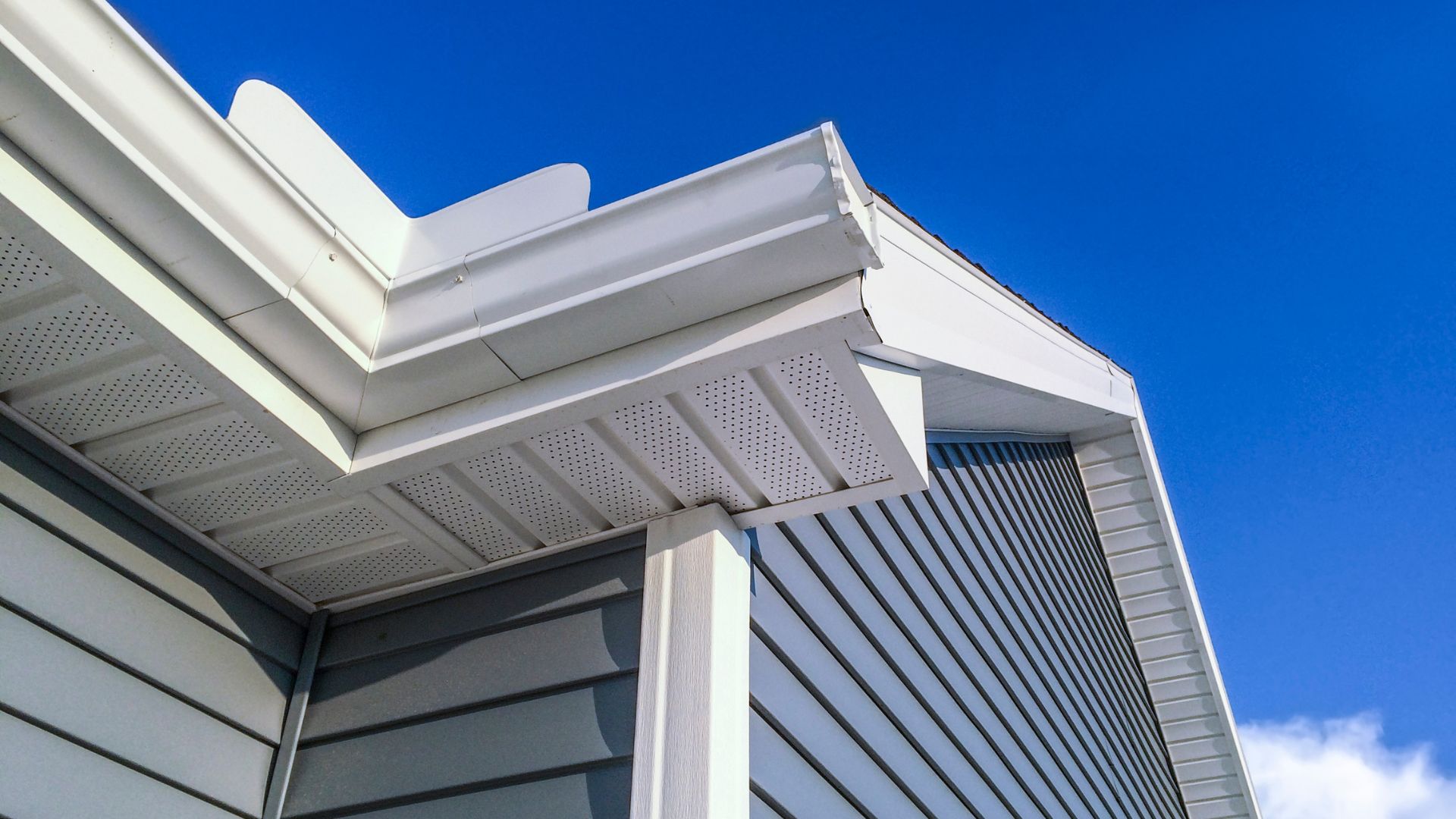 Modern white and gray building exterior with geometric roof details