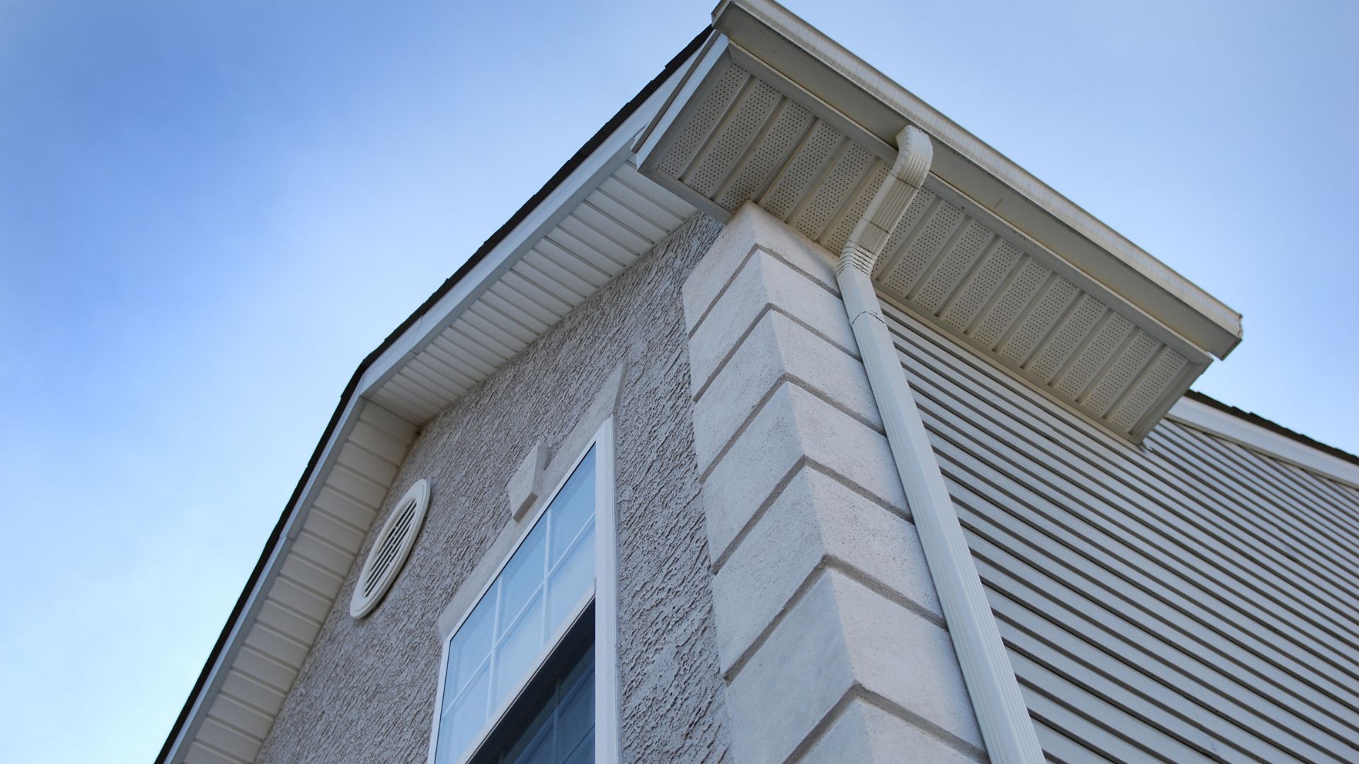 Modern house exterior corner with textured wall and blue sky